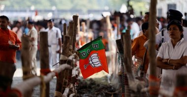 A Bharatiya Janata Party (BJP) flag hangs on fencing as people wait for the swearing-in ceremony of BJP leader Suvendu Adhikari as the West Bengal Chief Minister, Kolkata, India, May 9, 2026. (Reuters Photo)