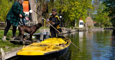 Mailperson Andrea Bunar delivers mail from a boat during the first tour of the summer in the village of Lehde, Luebbenau, Germany, April 29, 2026. (AP Photo)