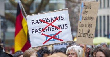 A poster rejecting "racism, fascism, AfD" can be seen at the "human chain for diversity" in Hesse, Wiesbaden, Germany, Feb. 22, 2025. (dpa Picture-Alliance via AFP File Photo))