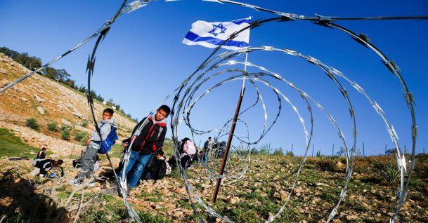 Palestinian students gather near a fence installed by Israeli settlers in their way to school, near Umm al-Khair village in Masafer Yatta, in the Israeli-occupied West Bank, Palestine, April 14, 2026. (Reuters Photo)