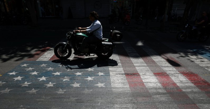 A person rides a motorcycle over a U.S. flag painted on a street in Tehran, Iran, May 12, 2026. (Reuters Photo)
