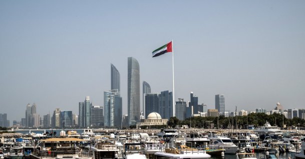 The United Arab Emirates flag flutters against the backdrop of the Abu Dhabi Skyline following a reported Iranian strike, March 1, 2026. (AFP File Photo)