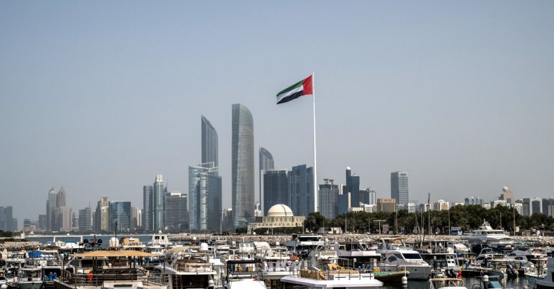 The United Arab Emirates flag flutters against the backdrop of the Abu Dhabi Skyline following a reported Iranian strike, March 1, 2026. (AFP File Photo)