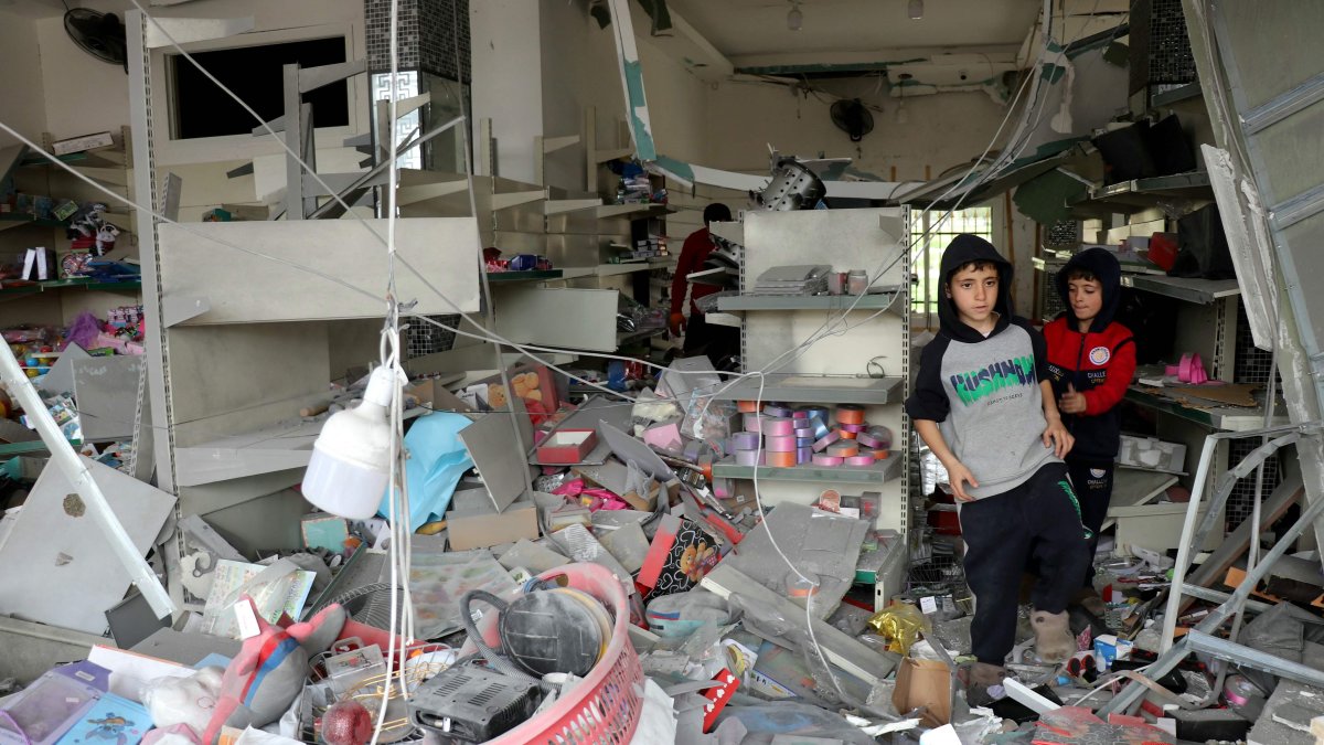 Children walk through a damaged store as displaced residents return to the southern Lebanese village of Srifa, April 19, 2026. (AFP File Photo)