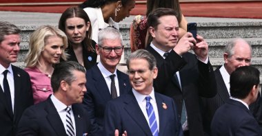 U.S. Secretary of Defense Pete Hegseth (bottom L) speaks with U.S. Treasury Secretary Scott Bessent (bottom center R), as Tesla and SpaceX CEO Elon Musk (top R) uses his phone and Apple CEO Tim Cook (C) looks on at a welcome ceremony for US President Donald Trump at the Great Hall of the People in Beijing, China, May 14, 2026. (AFP Photo)