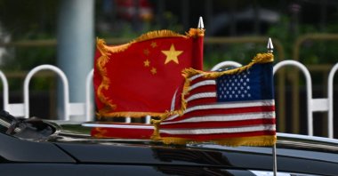 The U.S. and China flags are seen on a vehicle in the motorcade of U.S. President Donald Trump as it leaves the hotel in Beijing, China, May 14, 2026. (AFP Photo)
