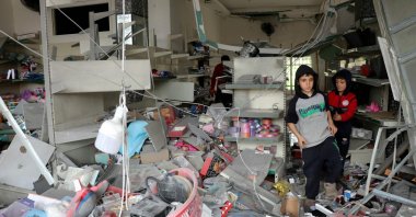 Children walk through a damaged store as displaced residents return to the southern Lebanese village of Srifa, April 19, 2026. (AFP File Photo)