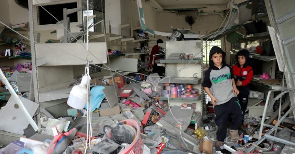 Children walk through a damaged store as displaced residents return to the southern Lebanese village of Srifa, April 19, 2026. (AFP File Photo)