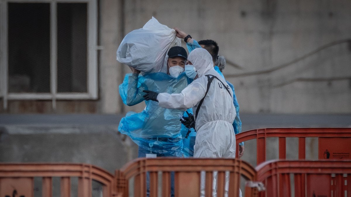 27 passengers disembark and head toward Tenerife Airport to board two flights to the Netherlands, while military and civilian personnel involved in the evacuation operation wear protective suits as a precaution against potential virus transmission, Santa Cruz de Tenerife, Spain, May 11, 2026. (Reuters Photo)