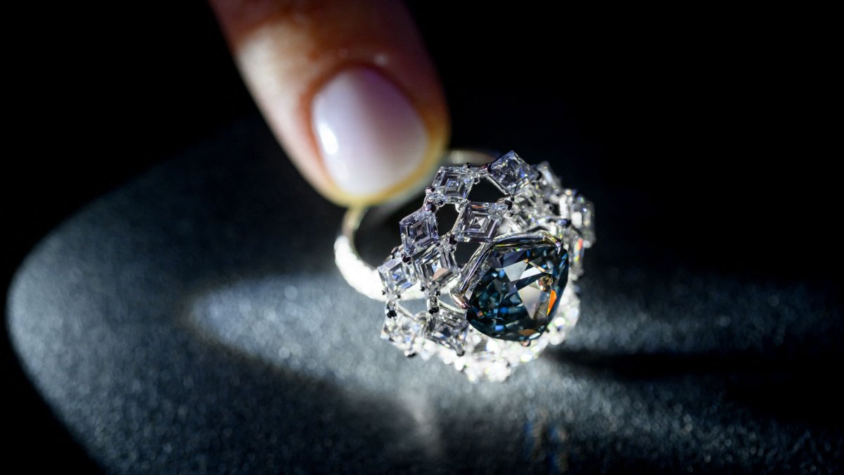 A photograph shows a triangular-shaped fancy vivid blue-green diamond weighing 5.50 carats, known as "The Ocean Dream," displayed during a press preview at Christie’s auction house, Geneva, Switzerland, May 7, 2026. (AFP Photo)