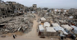 Palestinians walk past the rubble of residential buildings destroyed during the two-year Israeli attacks, in Khan Younis, southern Gaza Strip, April 15, 2026. (Reuters File Photo)