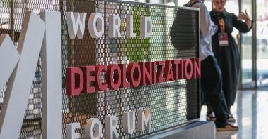 People stand near the entrance logo of the World Decolonization Forum at the Atatürk Cultural Center (AKM), Istanbul, Türkiye, May 11, 2026. (AA Photo)