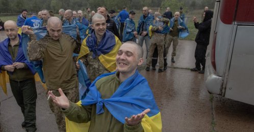Released Ukrainian prisoners of war (POWs) wrapped with Ukrainian national flags react following a prisoner exchange at an undisclosed location, amid the Russian invasion of Ukraine, Chernihiv, Ukraine, May 15, 2026. (AFP Photo)