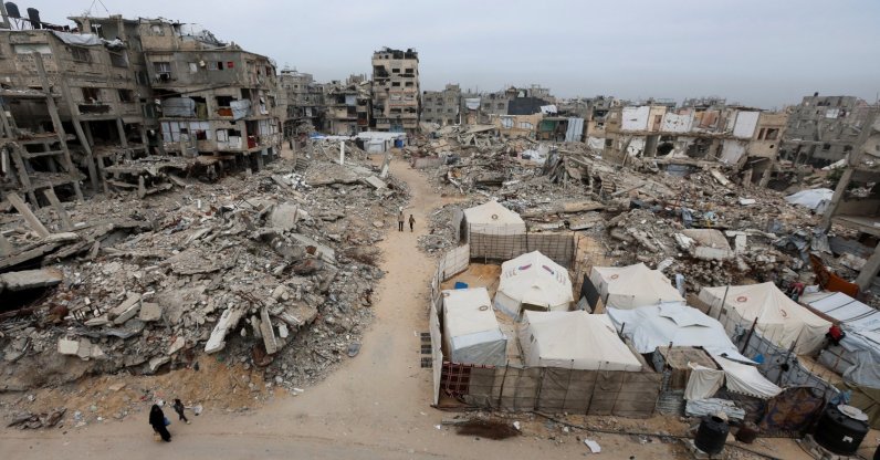 Palestinians walk past the rubble of residential buildings destroyed during the two-year Israeli attacks, in Khan Younis, southern Gaza Strip, April 15, 2026. (Reuters File Photo)