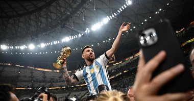 Argentina's captain and forward #10 Lionel Messi (R) holds the FIFA World Cup Trophy following the trophy ceremony after Argentina won the Qatar 2022 World Cup final against France at Lusail Stadium in Lusail, Doha, Qatar, Dec. 18, 2022. (AFP Photo)