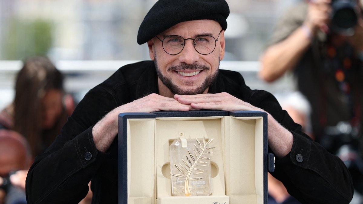 John Travolta poses with an honorary lifetime achievement Palme d'Or award during a photocall of the film "Vol de nuit pour Los Angeles" ("Propeller One-Way Night Coach") at the 79th edition of the Cannes Film Festival, Cannes, France, May 16, 2026. (AFP Photo)