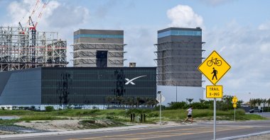 A jogger crosses Boca Chica Boulevard near the SpaceX production facility as preparations continue for the 12th test flight of the Starship spacecraft and the Super Heavy booster in Starbase, Texas, U.S., May 16, 2026. (Reuters Photo)