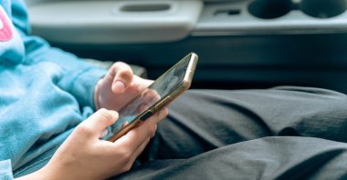 A child uses a smartphone as authorities prepare new regulations restricting social media access for users under the age of 15. (Shutterstcok Photo) 