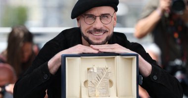 John Travolta poses with an honorary lifetime achievement Palme d'Or award during a photocall of the film "Vol de nuit pour Los Angeles" ("Propeller One-Way Night Coach") at the 79th edition of the Cannes Film Festival, Cannes, France, May 16, 2026. (AFP Photo)