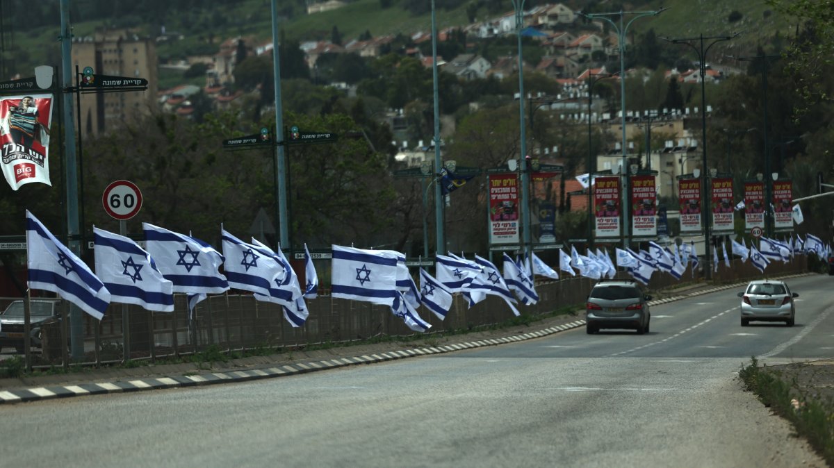 Cars drive along a road lined with Israeli flags, Kiryat Shmona, northern Israel, April 17, 2026. (EPA Photo)