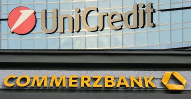 This combination of pictures shows the logo of Italian bank Unicredit in Milan (top), Italy, Dec.18, 2024, and the logo of German bank Commerzbank on one of the bank's branches in Berlin, Germany, May 13, 2020. (AFP Photo)