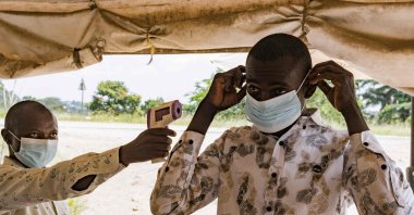 A border health officer at the Busunga crossing between Uganda and the Democratic Republic of Congo checks a traveler’s temperature using a contactless infrared thermometer in Bundibugyo, May 18, 2026. (AFP Photo)