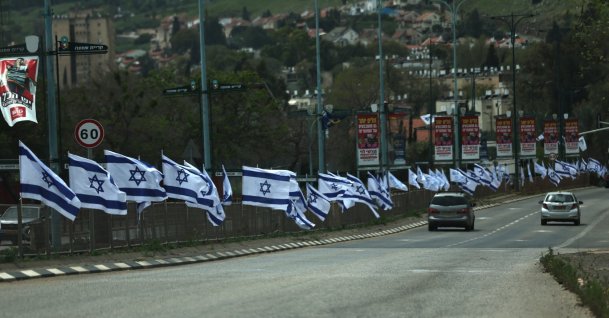 Cars drive along a road lined with Israeli flags, Kiryat Shmona, northern Israel, April 17, 2026. (EPA Photo)