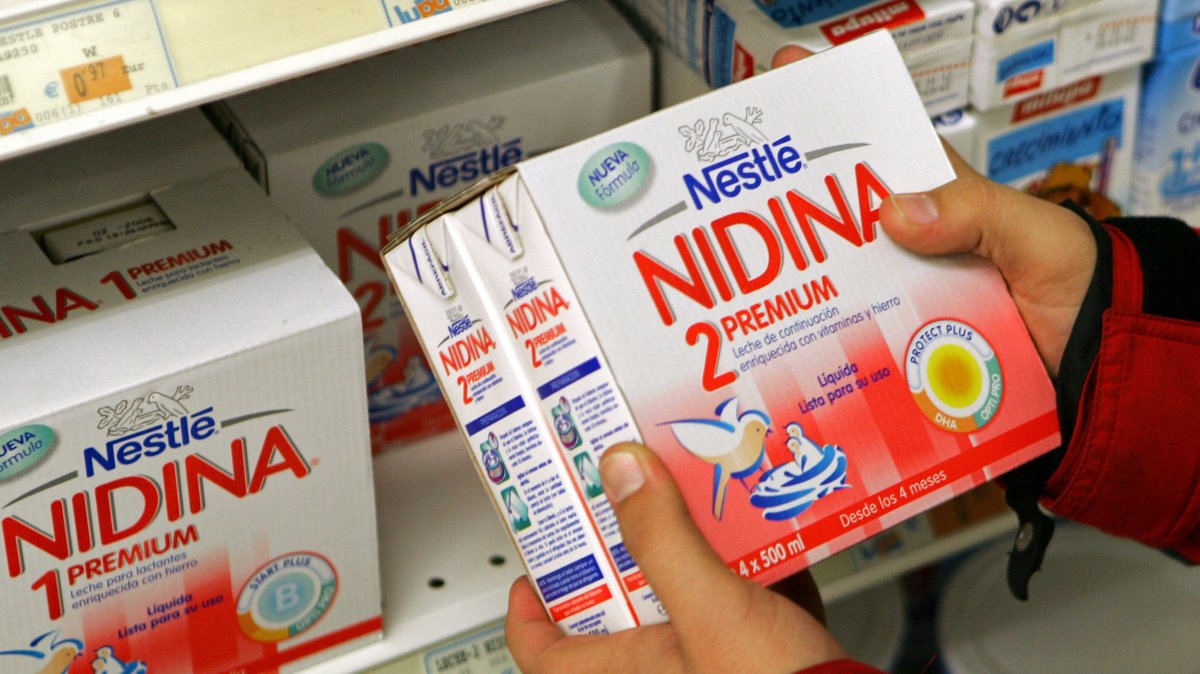 A customer holds a box of baby milk by Swiss food group Nestle in a shop in Santander, northern Spain, Nov. 22, 2005. (Reuters Photo)