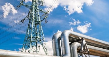 A pipeline and a power grid are seen in this stock photo. (Shutterstock Photo)