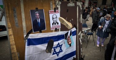 Protesters gather in a square where they display an Israeli flag alongside images of Israeli Prime Minister Benjamin Netanyahu and far-right minister Itamar Ben-Gvir, before throwing shoes at the flag and the photos in protest, Amsterdam, Netherlands, May 15, 2026. (AA Photo)
