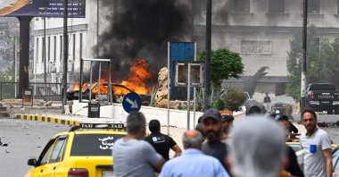 People watch a burning vehicle following an explosion in Damascus, Syria, May 19, 2026. (AFP Photo)