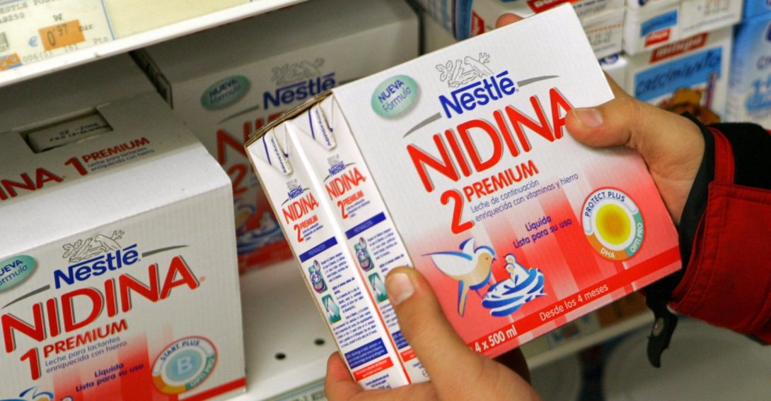 A customer holds a box of baby milk by Swiss food group Nestle in a shop in Santander, northern Spain, Nov. 22, 2005. (Reuters Photo)
