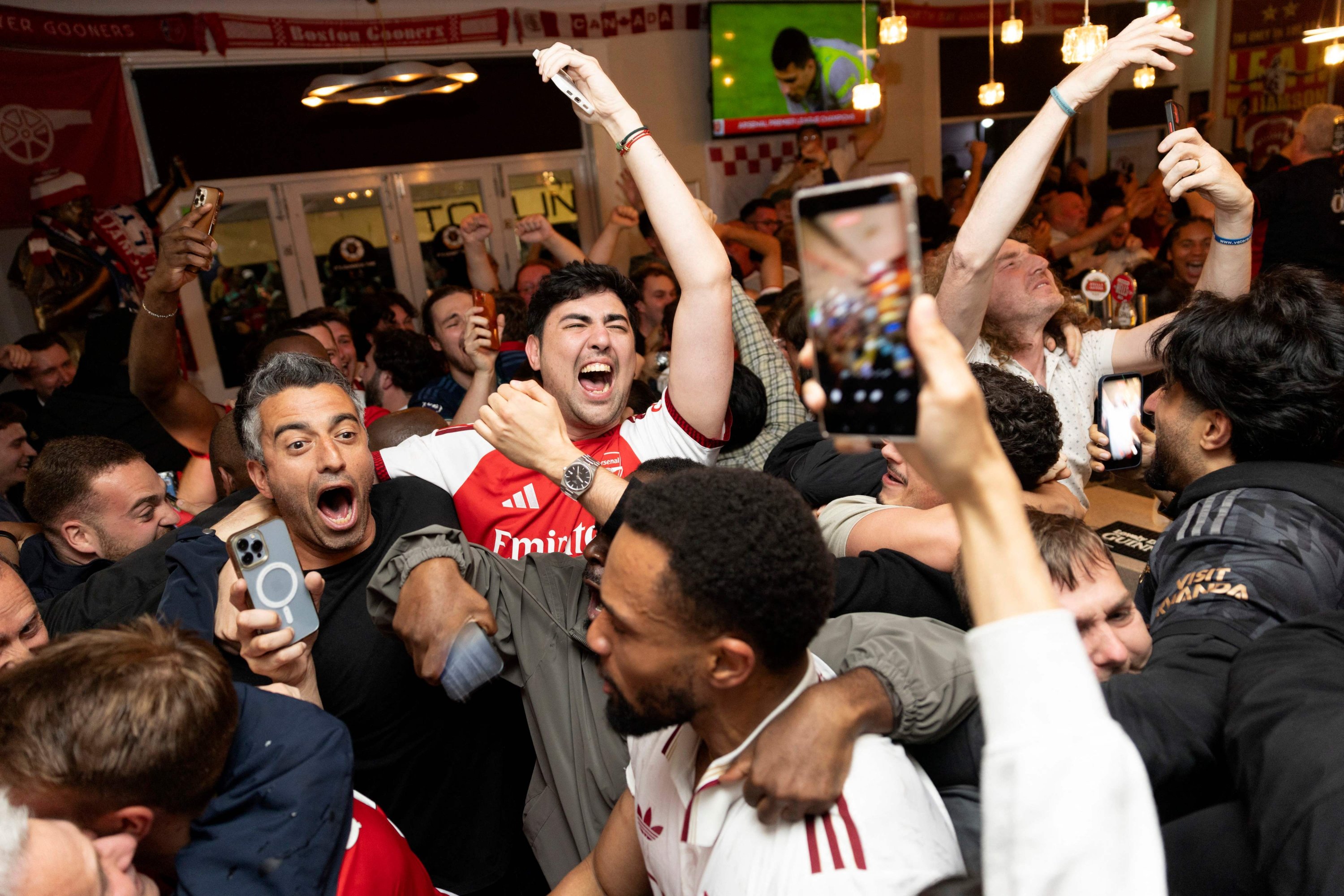 Arsenal fans celebrate their team winning the English Premier League, from inside the Tollington Arms pub near the Emirates Stadium,  London, U.K., May 19, 2026. (AFP Photo)