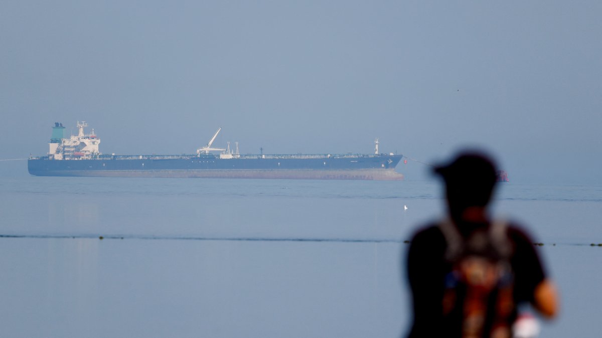 A tourist watches the MT Desert Kite oil tanker carrying Russian oil at Narara Marine National Park in the Arabian Sea, Gujarat, India, March 11, 2026. (Reuters Photo)