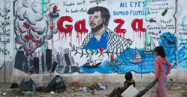 Palestinian children look at a mural depicting Israel's interception of ships participating in the Global Sumud Flotilla, in Nuseirat, central Gaza Strip, May 19, 2026. (AFP Photo)