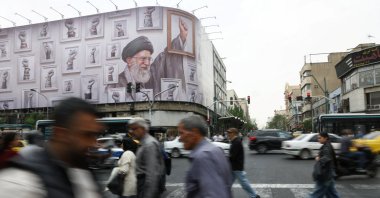 People walk near a billboard with an image of the late Iranian Supreme Leader Ayatollah Ali Khamenei, in Tehran, Iran, May 19, 2026. (WANA via Reuters)