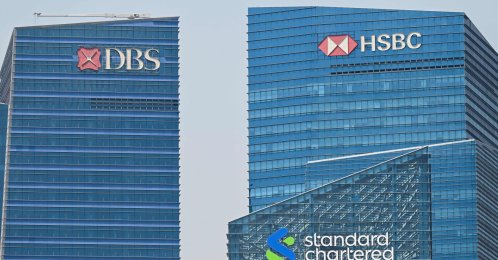 The logos of HSBC, DBS and Standard Chartered are seen on buildings in the Marina Bay financial centre in Singapore on May 5, 2026. (AFP Photo)