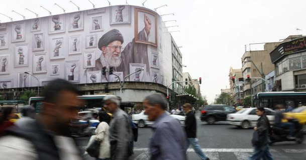 People walk near a billboard with an image of the late Iranian Supreme Leader Ayatollah Ali Khamenei, in Tehran, Iran, May 19, 2026. (WANA via Reuters)