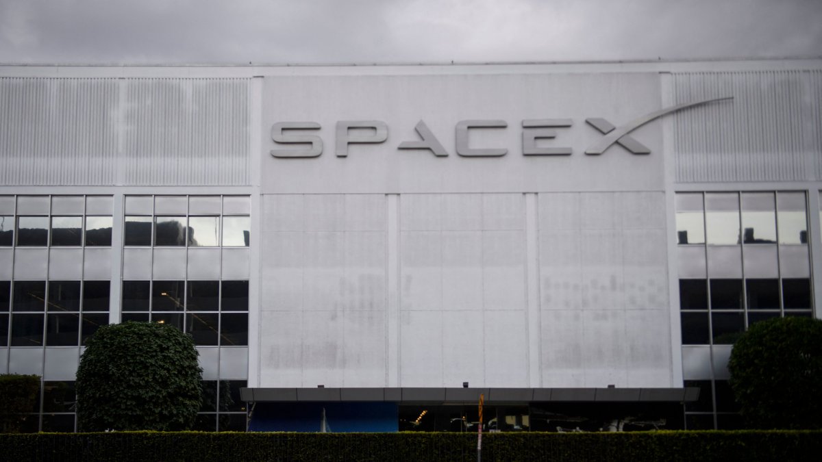 A pedestrian walks past the Space Exploration Technologies Corp. (SpaceX) former headquarters in Hawthorne, California, U.S., Jan. 28, 2021. (AFP Photo)
