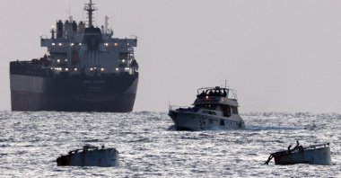 Israeli soldiers are seen on a vessel bearing symbols of the Global Sumud Flotilla, with a cargo ship behind it, as seen from Ashdod, southern Israel, May 19, 2026. (Reuters Photo) 