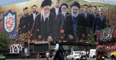 Iranians walk in front of a large billboard displaying pictures of late Iranian supreme leader Ayatollah Ali Khamenei and late Iranian president Ebrahim Raisi at the Enghelab Square in Tehran, Iran, May 21, 2026. (EPA Photo)