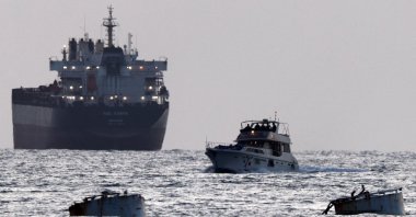 Israeli soldiers are seen on a vessel bearing symbols of the Global Sumud Flotilla, with a cargo ship behind it, as seen from Ashdod, southern Israel, May 19, 2026. (Reuters Photo)