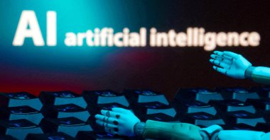 A message reading "AI artificial intelligence," a keyboard and robot hands are seen in this illustration created on Jan. 27, 2025. (Reuters File Photo)