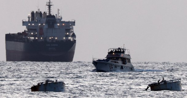 Israeli soldiers are seen on a vessel bearing symbols of the Global Sumud Flotilla, with a cargo ship behind it, as seen from Ashdod, southern Israel, May 19, 2026. (Reuters Photo) 