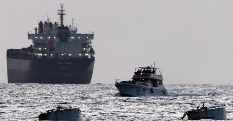 Israeli soldiers are seen on a vessel bearing symbols of the Global Sumud Flotilla, with a cargo ship behind it, as seen from Ashdod, southern Israel, May 19, 2026. (Reuters Photo)