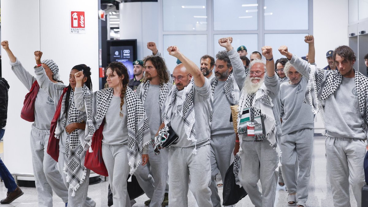 Italian activists from the Gaza-bound Global Sumud Flotilla, detained by Israeli forces after their vessels were intercepted in international waters in the Mediterranean, gesture upon arrival at Fiumicino Airport, Fiumicino, Italy, May 21, 2026. (AA Photo)
