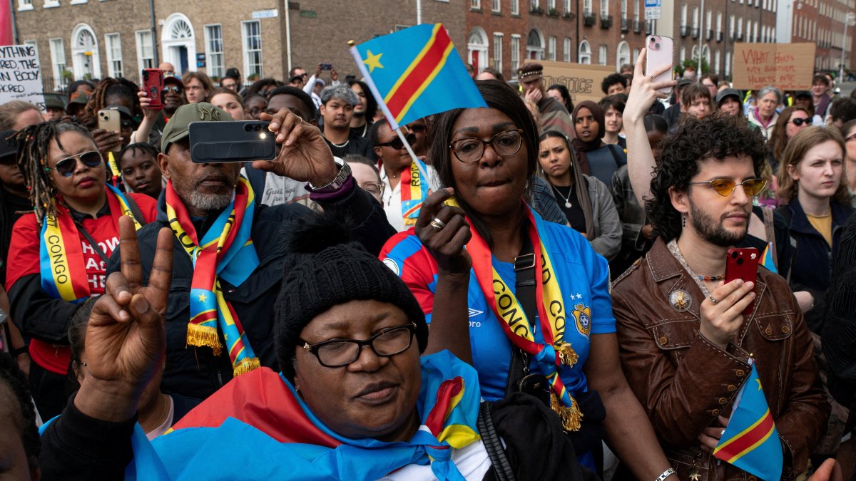 People hold flags during a protest following the death of Yves Sakila, a Congolese-born man who died after being restrained by security guards outside a department store, outside Leinster House, Dublin, Ireland, May 21, 2026. (Reuters Photo)