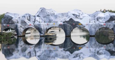 This photograph taken at the Pont-Neuf bridge shows the installation of "The Pont Neuf's cave," the newest artwork by French photographer and street artist JR, Paris, France, May 22, 2026. (AFP Photo)