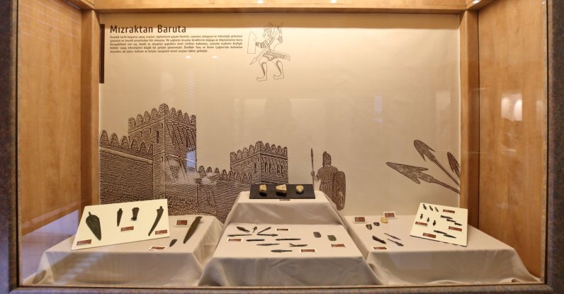 Bronze Age spearheads, stone axes and Ottoman-era firearms are displayed during the "From Spear to Gunpowder" exhibition at Çorum Museum, May 22, 2026. (AA Photo)