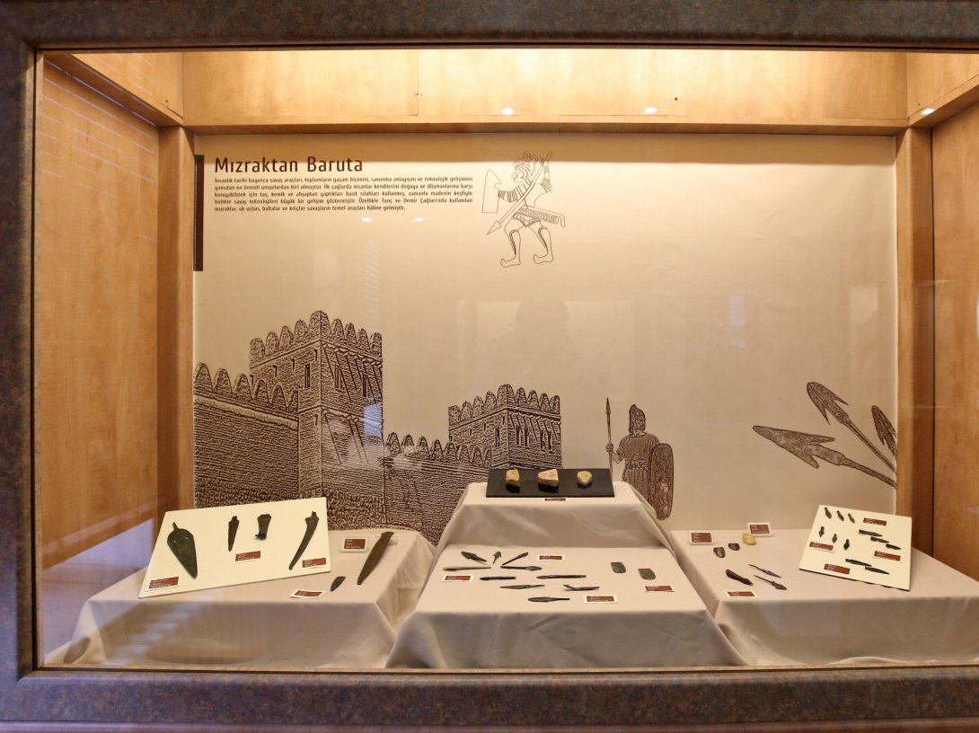 Bronze Age spearheads, stone axes and Ottoman-era firearms are displayed during the "From Spear to Gunpowder" exhibition at Çorum Museum, May 22, 2026. (AA Photo)